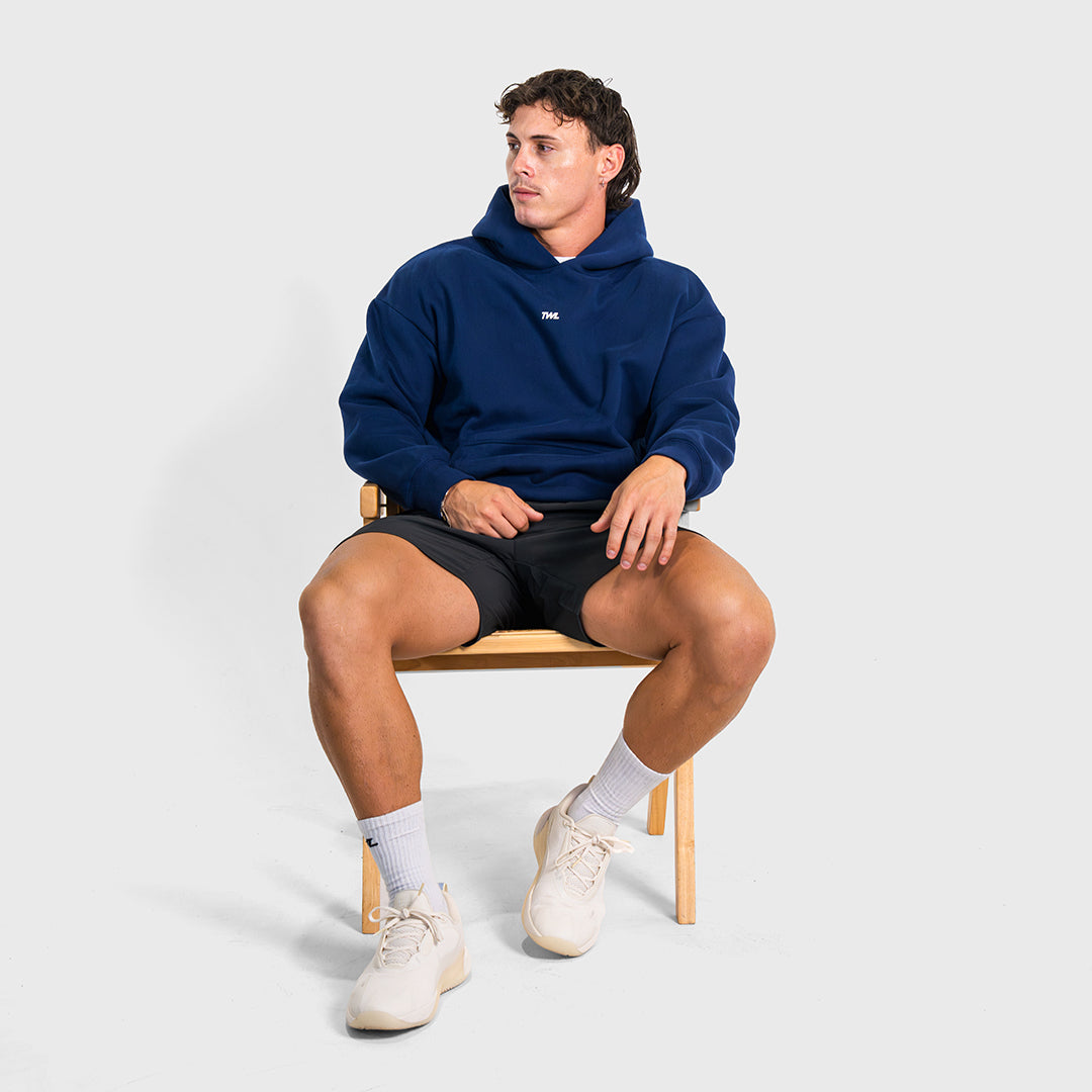 TWL Ascend Hoodie Navy – oversized fleece hoodie - model sitting in a chair