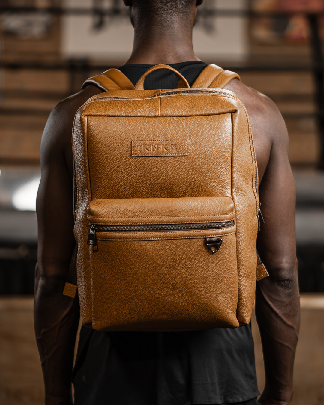 Man wearing tan leather KNKG HERITAGE Backpack