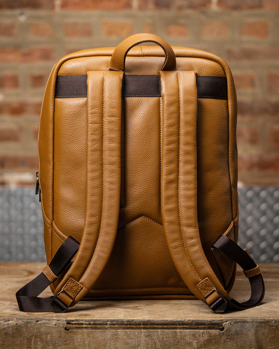Back view of padded shoulder straps of tan leather KNKG HERITAGE Backpack