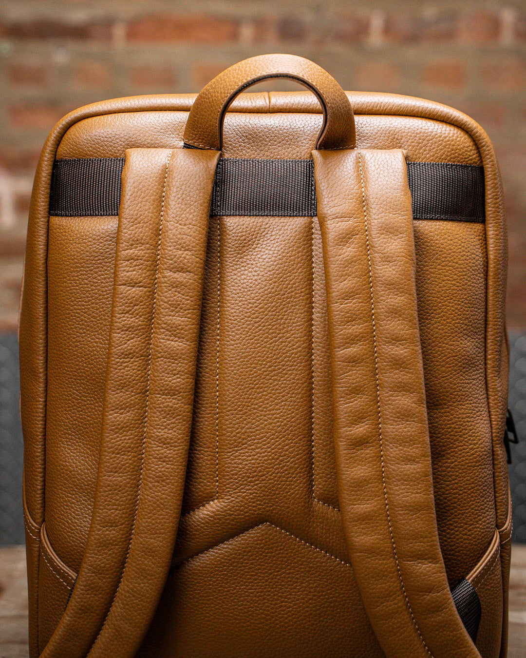 Close up of padded back panel of tan leather KNKG HERITAGE Backpack