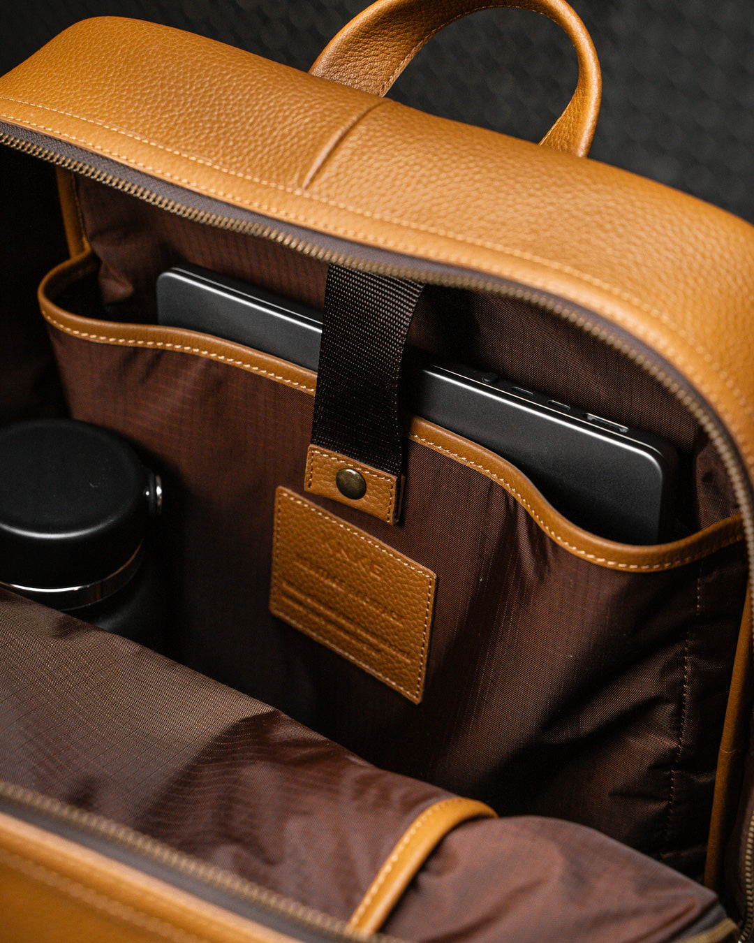 Laptop packed inside internal sleeve of tan leather KNKG HERITAGE Backpack