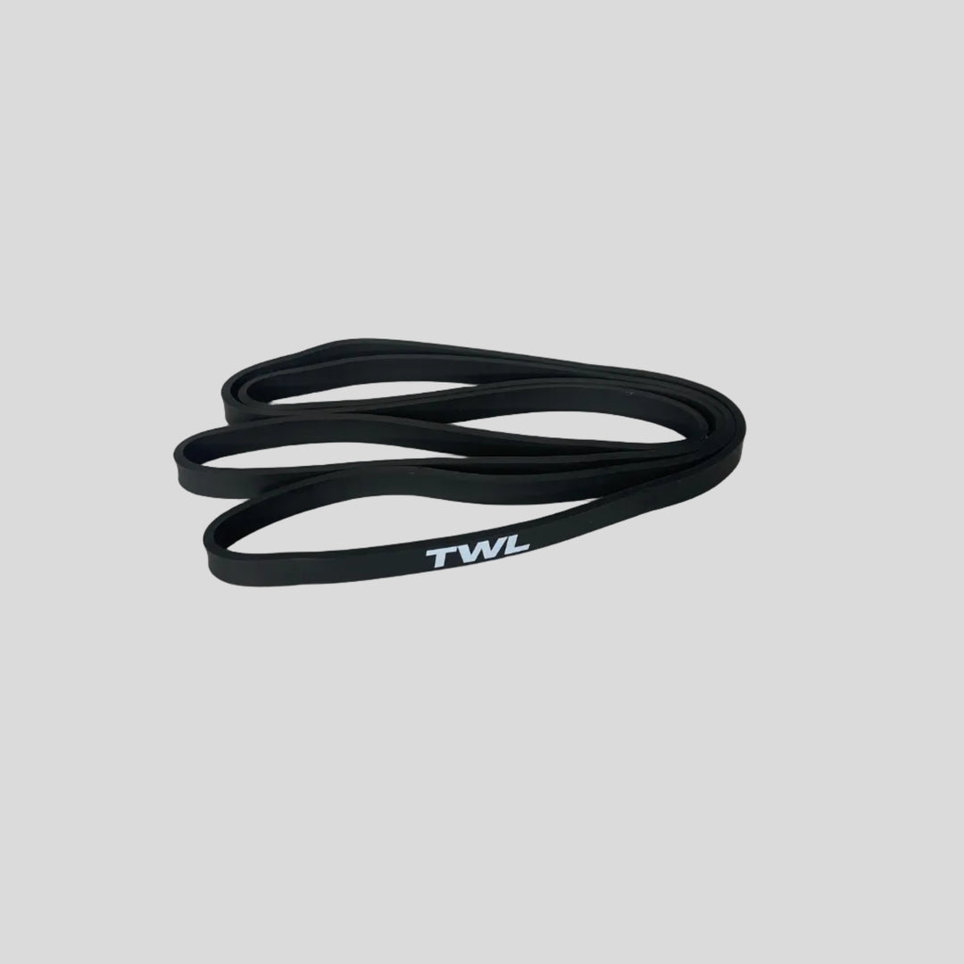 A black rubber resistance band with white 'TWL' lettering, coiled on a light gray surface.