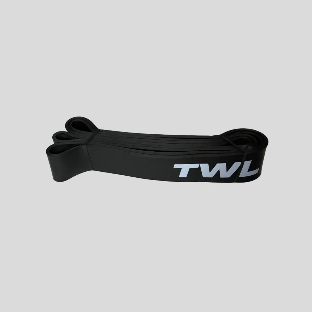 A black silicone resistance band with white 'TWL' branding, displayed on a light gray surface.