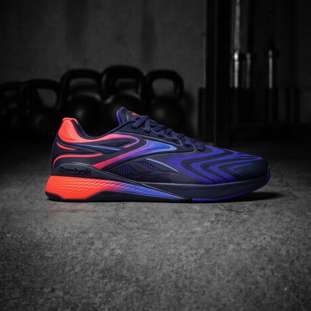 A Reebok athletic sneaker in a dark gym setting, featuring a navy blue upper with vibrant neon orange and purple gradient accents.