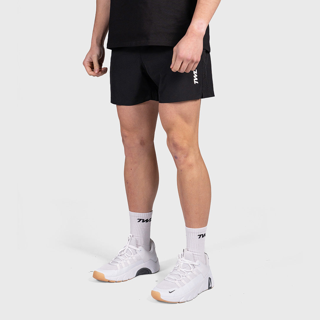 Man wearing the black TWL Men's Rep Shorts 5", full-length front view showing the fit